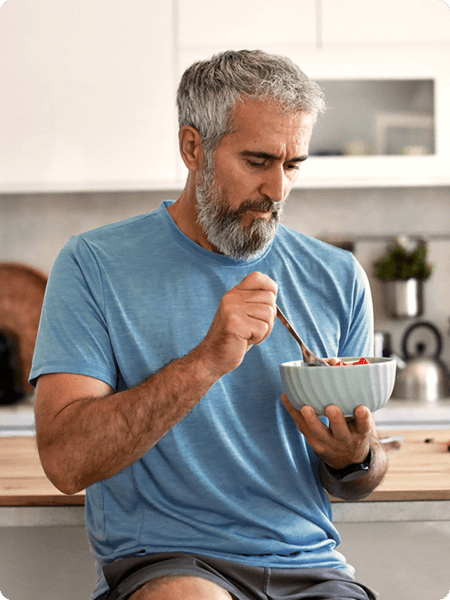 Man in blue shirt eating a bowl of food