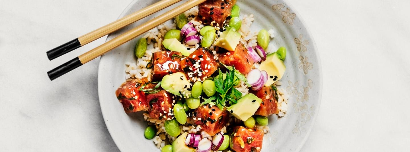 Bowl of rice with salmon, avocado, beans and onion