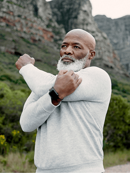 A man stretching his shoulder in nature 