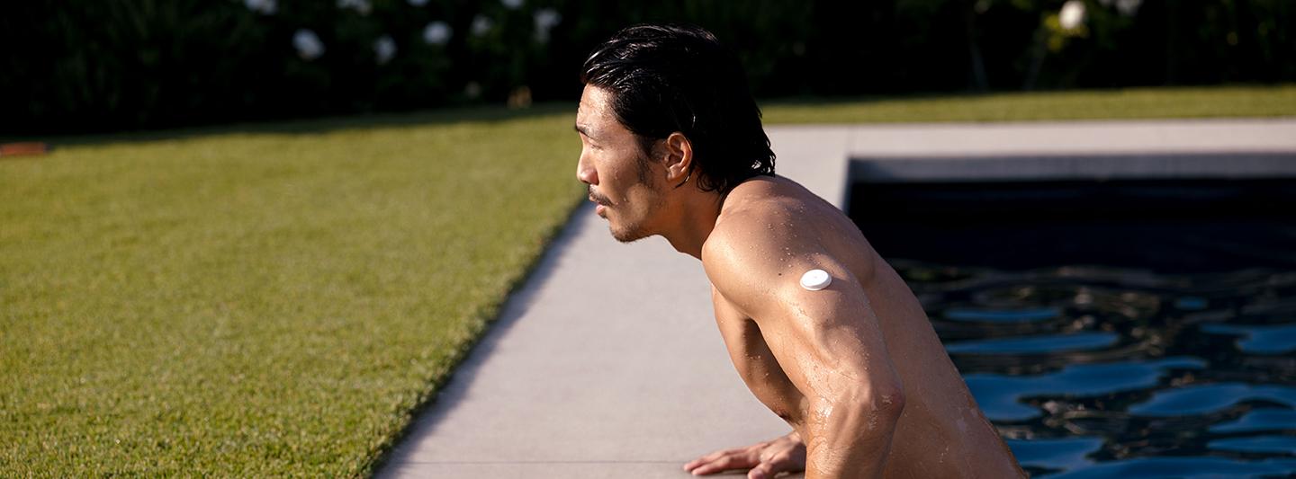 Male wearing a CGM in a swimming pool