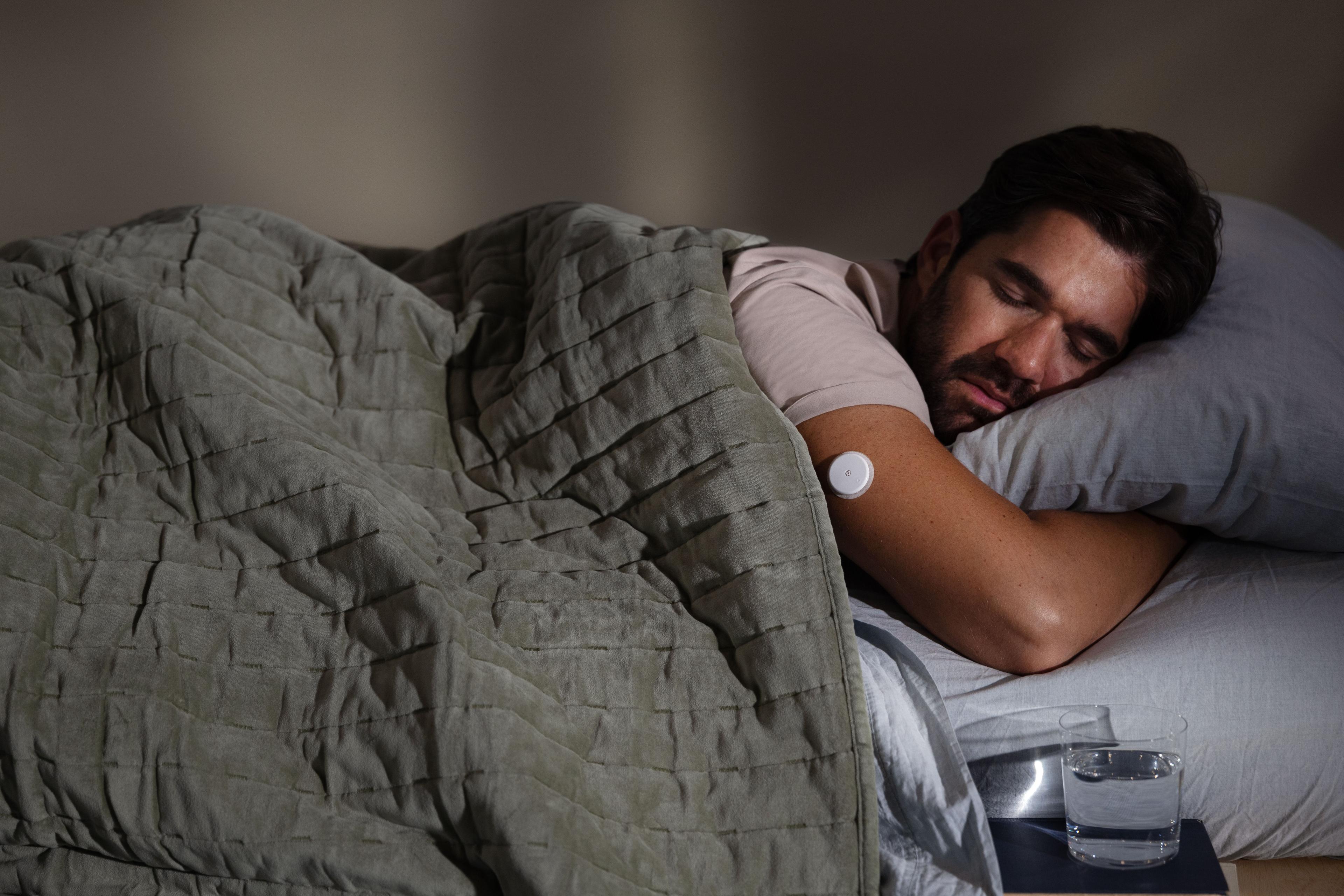 Man sleeping wearing a glucose monitor