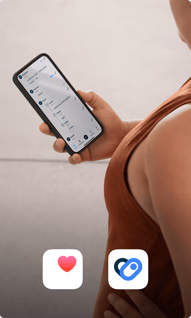 A person in a terracotta colored workout shirt checks her phone
