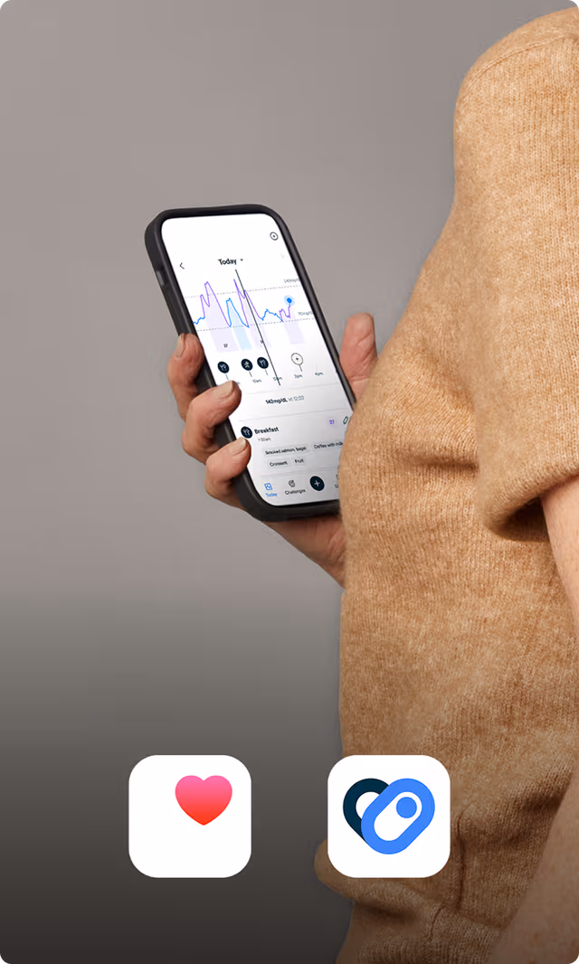 A person in a terracotta colored workout shirt checks her phone