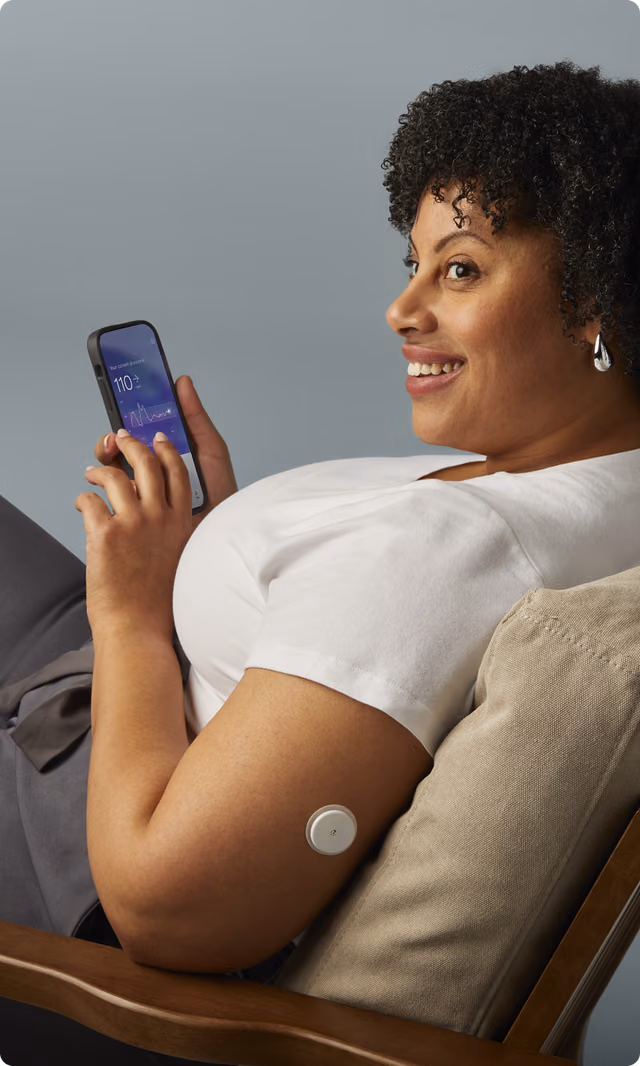 A woman looking at the Lingo app while wearing a Lingo biosensor