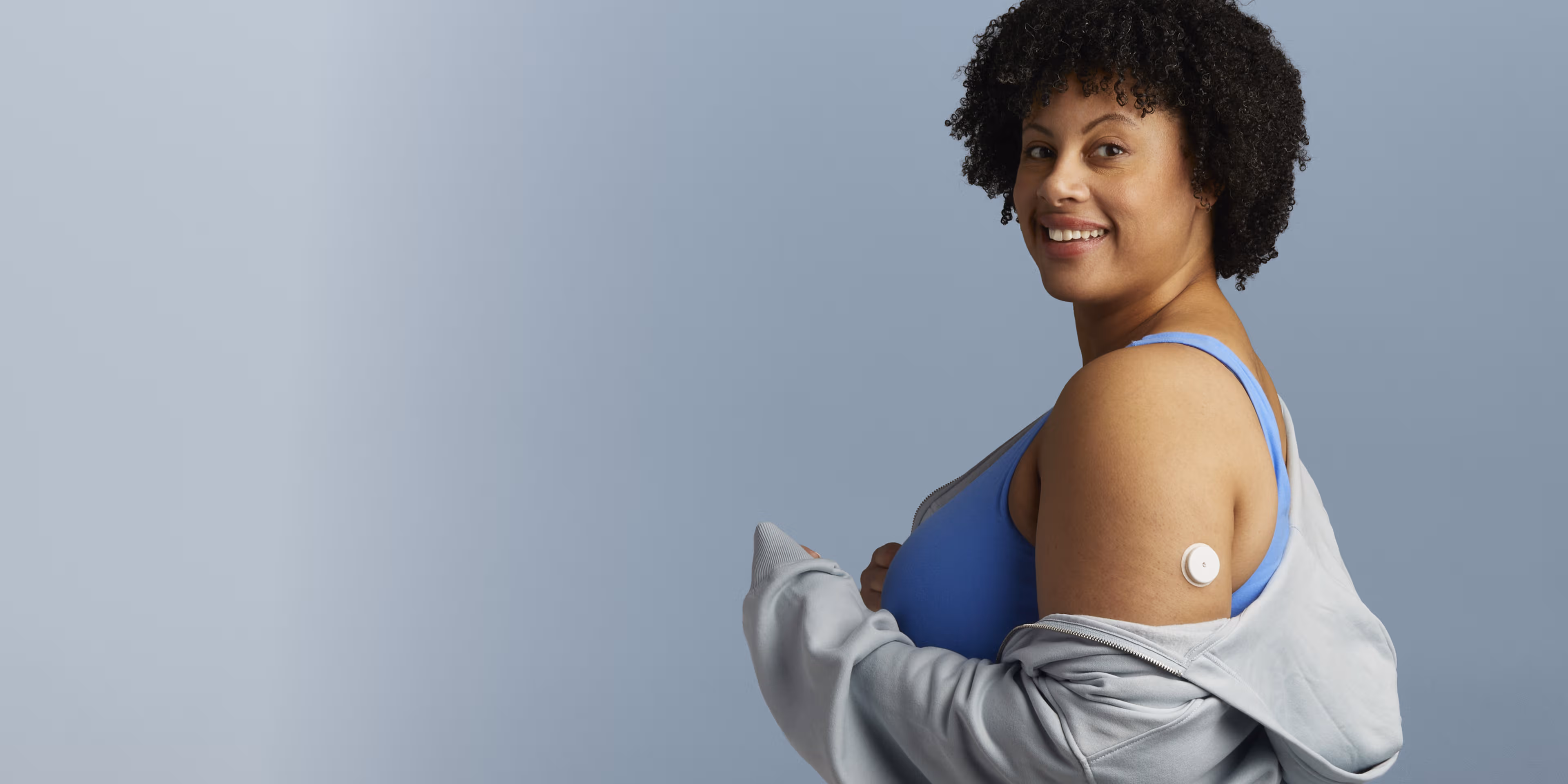 A woman wearing a Lingo Continuous Glucose Monitor