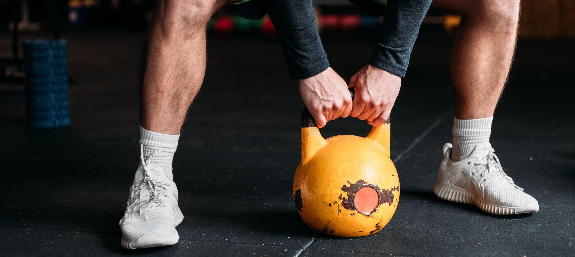 Lower body of someone lifting a kettlebell